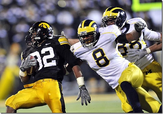 (caption) Michigan linebacker Jonas Mouton (8) and linebacker Craig Roh (far right) tackle Iowa running back Adam Robinson (32). Robinson rushed for 70 yards on 10 carries. *** Despite a late touchdown drive engineered by backup freshman QB Denard Robinson, the Michigan Wolverines came up short, losing to the unbeaten Iowa Hawkeyes 30-28 at Kinnick Stadium in Iowa City, Iowa. Photos taken on Saturday, October 10, 2009.  ( John T. Greilick / The Detroit News )

