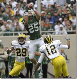 (CAPTION INFORMATION)
Michigan State's Blair White leaps high for a first quarter reception over the top of Michigan's Troy Woolfolk, left, and J.T. Floyd.      Photos are of Michigan State University vs. the University of Michigan at Spartan Stadium in East Lansing, October 3, 2009.   (The Detroit News / David Guralnick)
