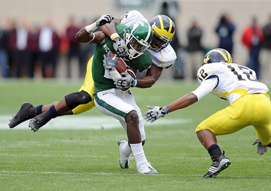 Michigan's Obi Ezeh, top, and J.T. Floyd, right, team up to bring down  Michigan State University wide receiver Mark Dell after a short gain during first quarter action of Saturday afternoon, October 3rd's clash between the in-state rivals at Spartan Stadium in East Lansing. 
Lon Horwedel | AnnArbor.com