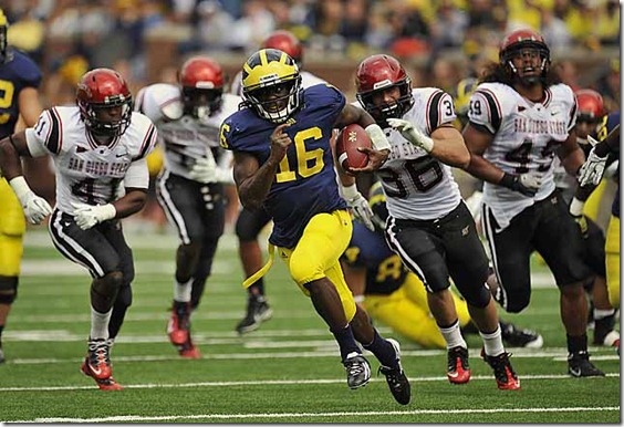 (caption) Michigan quarterback Denard Robinson breaks away from the San Diego State defense for a big gain in the second quarter. Robinson rushed for 200 yards and three touchdowns on 21 carries, a 9.5-yards-per-carry average. He struggled in the passing game, however, completing just 8 of 17 passes for 93 yards with two interceptions.  *** After jumping out to a 21-0 lead by halftime, courtesy of three rushing touchdowns by Michigan quarterback Denard Robinson, the Wolverines turned the ball over three times in the second half, but held on to beat coach Brady Hoke's former team, the San Diego State Aztecs 28-7 at Michigan Stadium in Ann Arbor. Photos taken on Saturday, September 24, 2011. ( John T. Greilick / The Detroit News )
