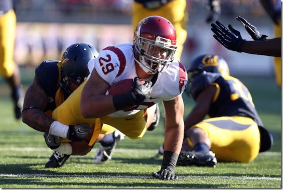Nov 9, 2013; Berkeley, CA, USA; USC Trojans running back Ty Isaac (29) carries the ball against California Golden Bears safety Michael Lowe (5) during the third quarter at Memorial Stadium. The USC Trojans defeated the California Golden Bears 62-28. Mandatory Credit: Kelley L Cox-USA TODAY Sports
