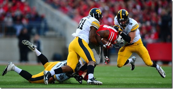 Oct 19, 2013; Columbus, OH, USA; Ohio State Buckeyes running back Carlos Hyde (34) is tackled by Iowa Hawkeyes defensive back Tanner Miller (5) and linebacker Anthony Hitchens (31) during the fourth quarter at Ohio Stadium. Mandatory Credit: Andrew Weber-USA TODAY Sports